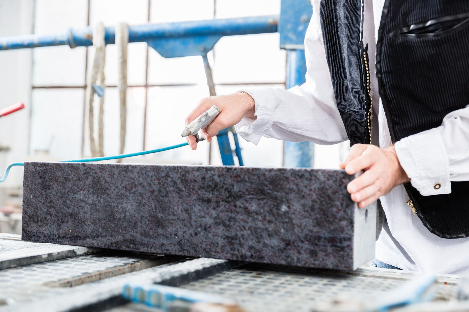 Stonemason working with compressed air at gravestone