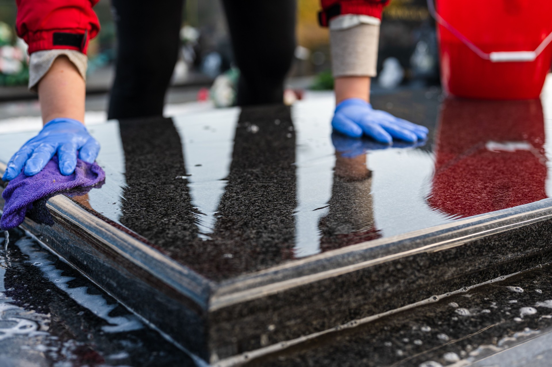 Marble tombstone being washed by woman